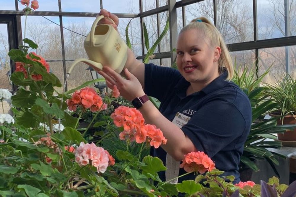 Employee watering plants at Oak Hill Supportive Living Community in Round Lake Beach, Illinois