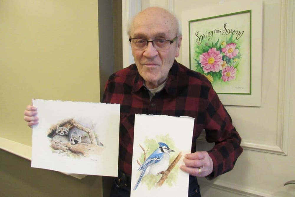 Resident with his paintings at Aspired Living of Westmont