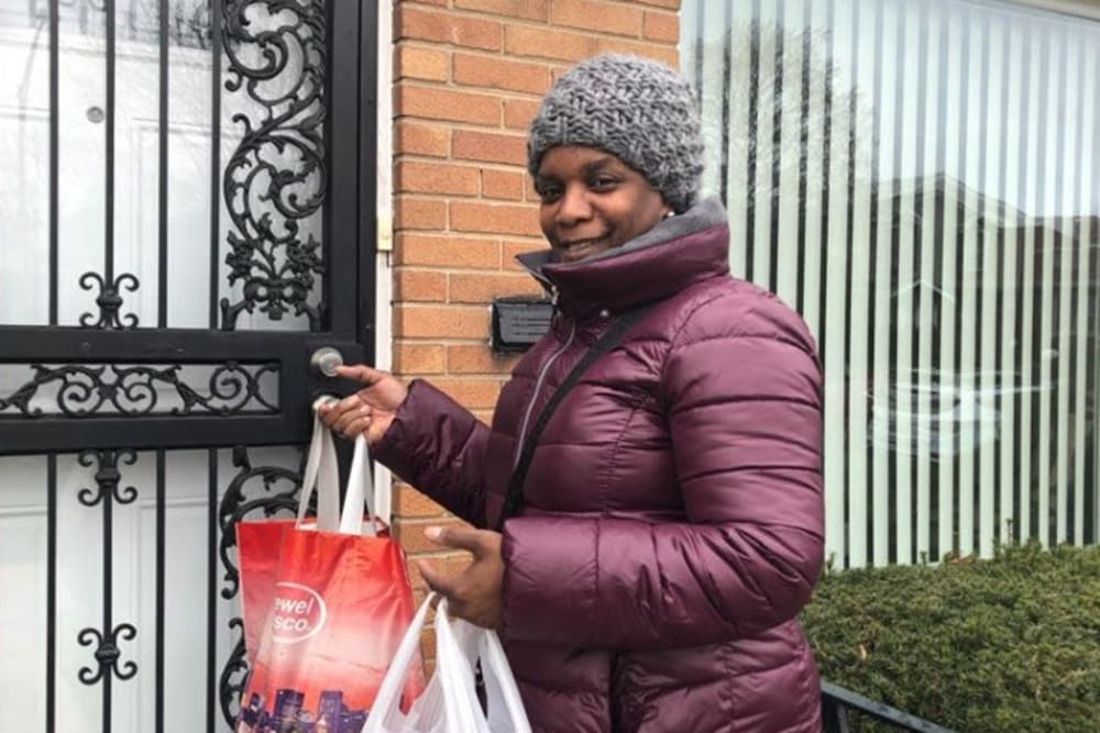 Employee delivering food to residents at Victory Centre of South Chicago