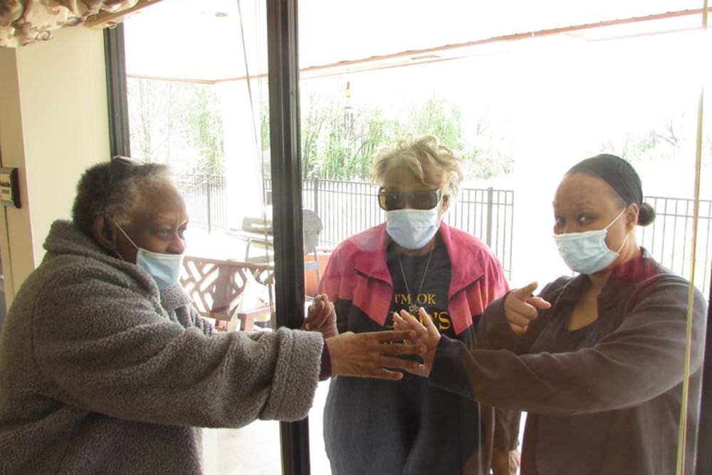 Resident with socially distanced visitors at Victory Centre of River Oaks