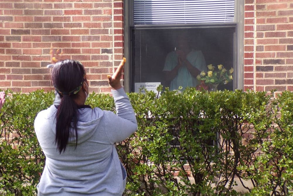 Resident with a socially distanced visitor at Victory Centre of Joliet