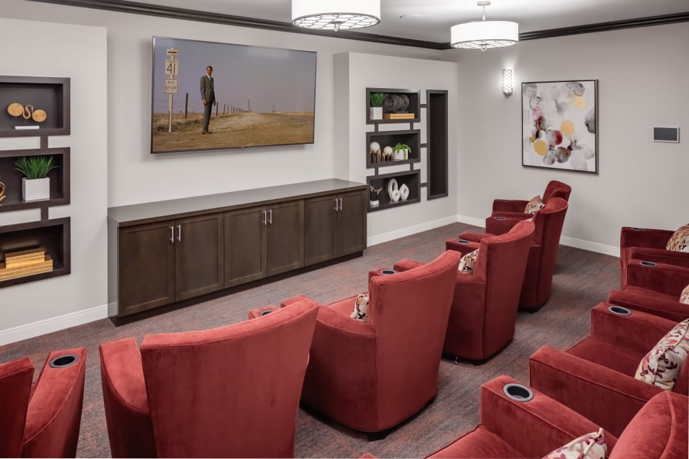 Theater area with rows of velvet red seats at Aspired Living of La Grange in La Grange, Illinois