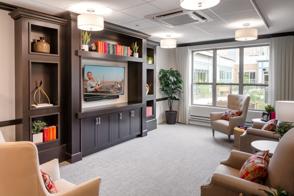 Tv lounge with a row of plush chairs at Aspired Living of La Grange in La Grange, Illinois
