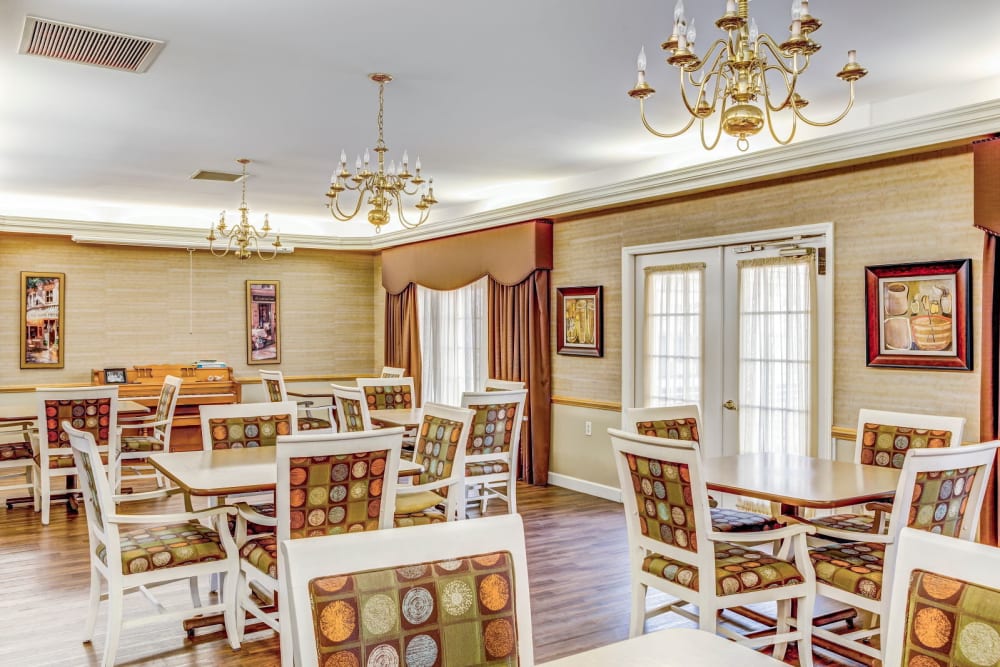 Community dining area with elegant chandeliers and wall drapes at Carriage Court of Washington Court House in Washington Court House, Ohio