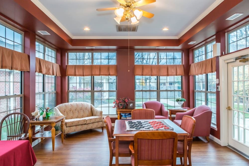 Cozy sitting room with wood accents, armchair seating, and chess set at Carriage Court of Lancaster in Lancaster, Ohio