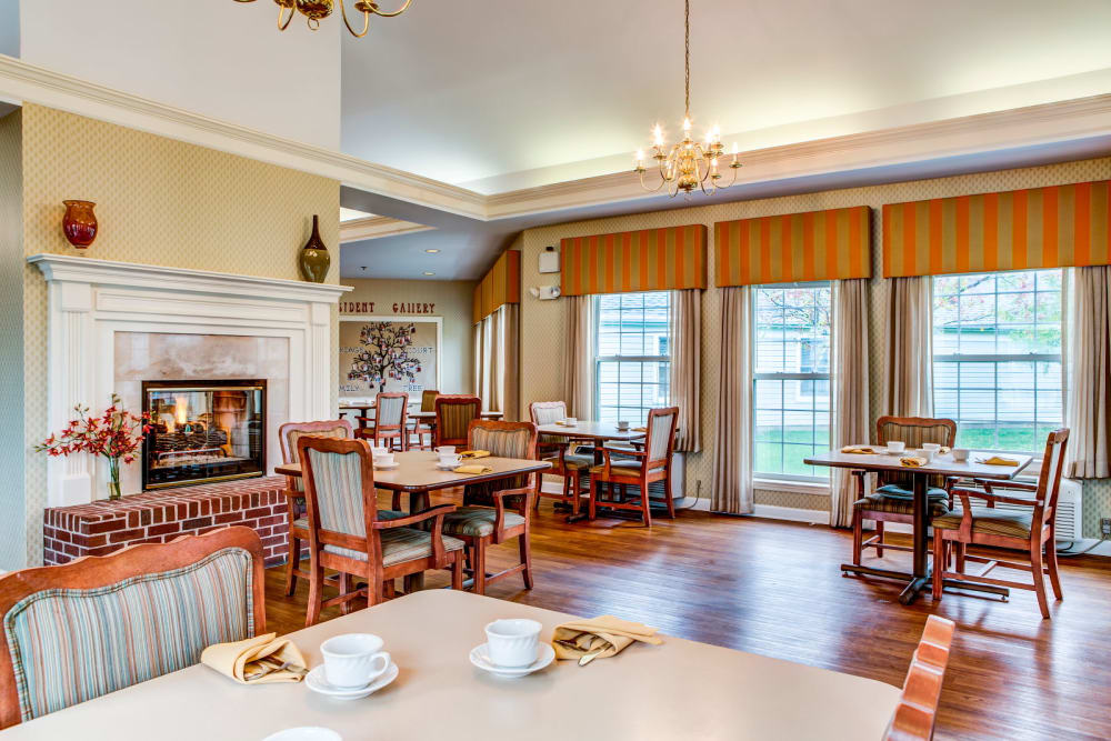 Commual dining area with elegant fireplace and wood accents at Carriage Court of Grove City in Grove City, Ohio