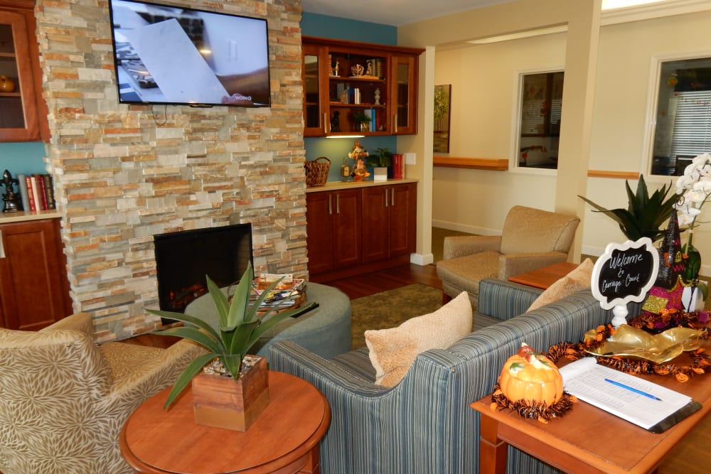 TV lounge area with comfy sofas and foliage at Carriage Court of Grove City in Grove City, Ohio