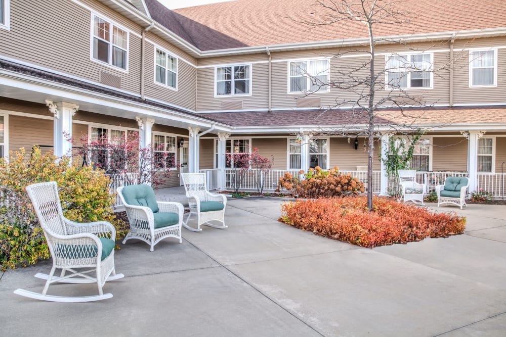 Outside courtyard with ample seating and foliage at Grand Victorian of Sycamore in Sycamore, Illinois