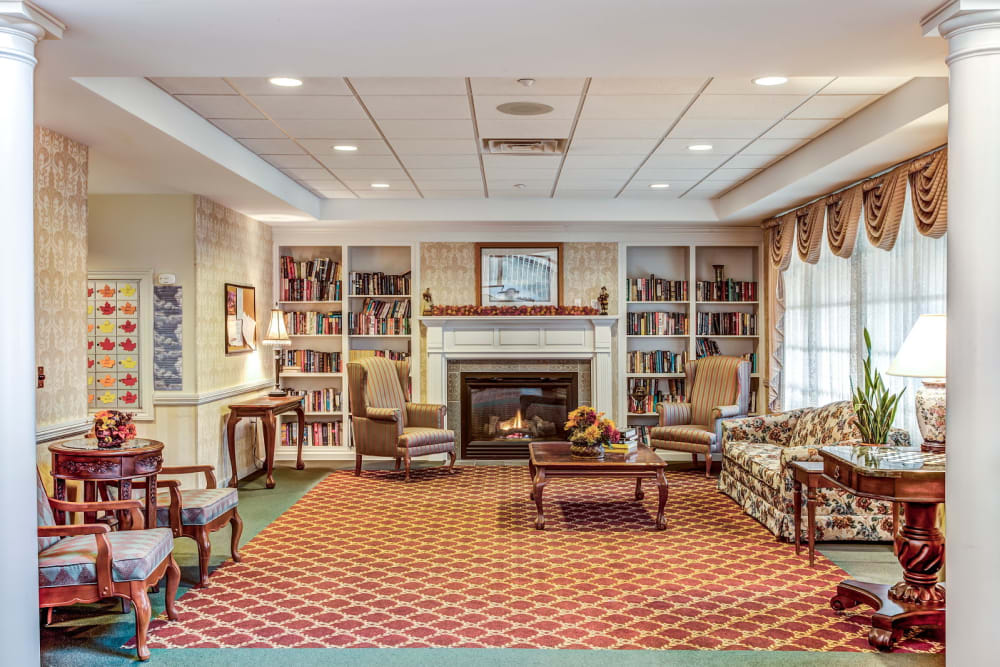 Cozy sitting room with fireplace and bookcases at Grand Victorian of Sycamore in Sycamore, Illinois