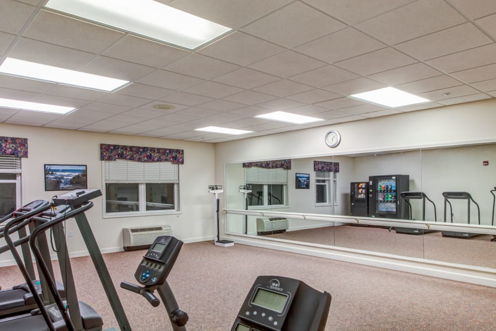 Deluxe gym with machinery and mirror at Grand Victorian of Sycamore in Sycamore, Illinois