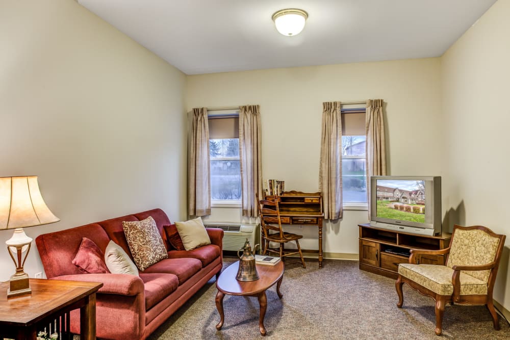 Well lit seating area of upscale senior living apartment at Grand Victorian of Sycamore in Sycamore, Illinois