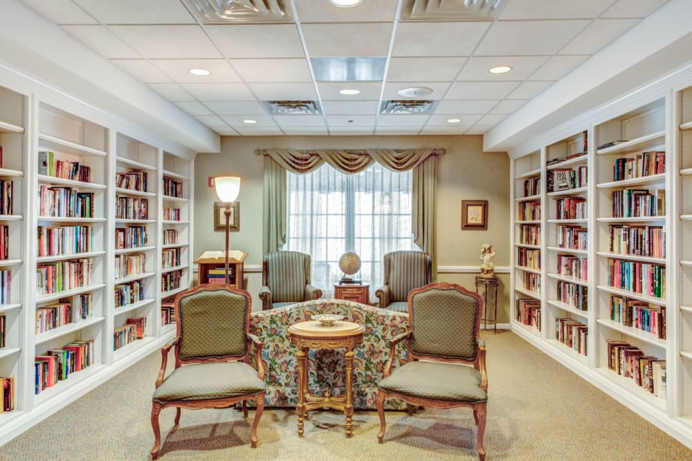 Comfortable lounge with seating and bookshelves at Grand Victorian of Rockford in Rockford, Illinois