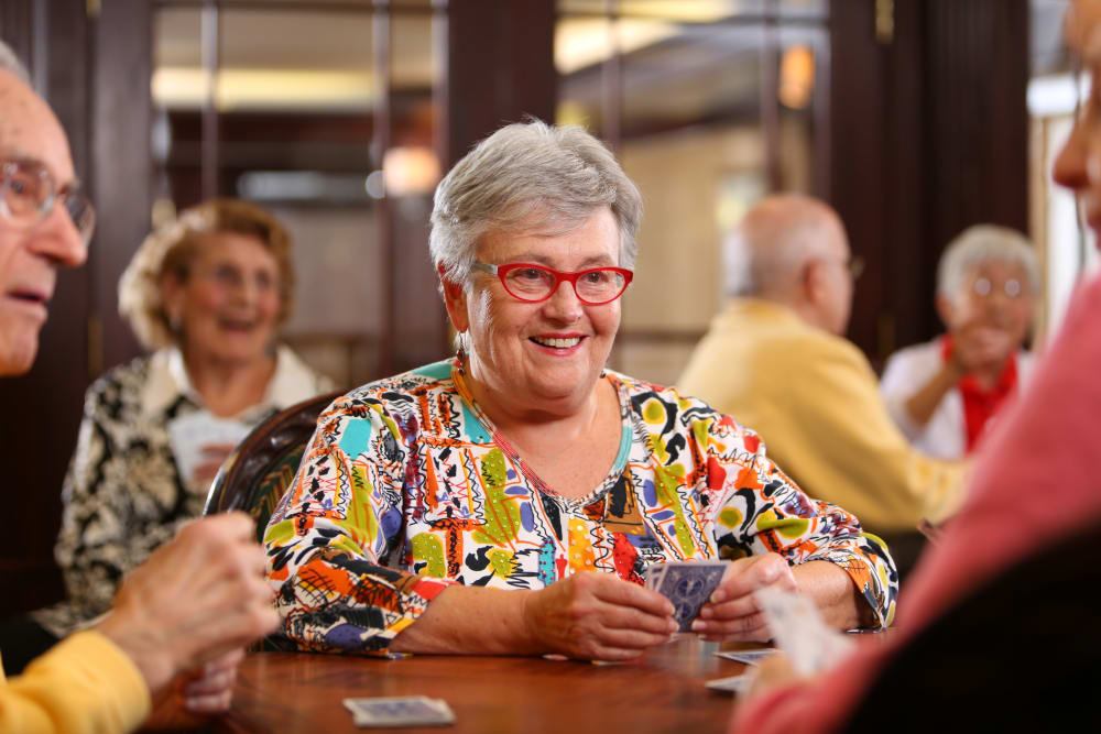 Happy senior living residents playing cards at Brookstone Estates of Charleston in Charleston, Illinois.
