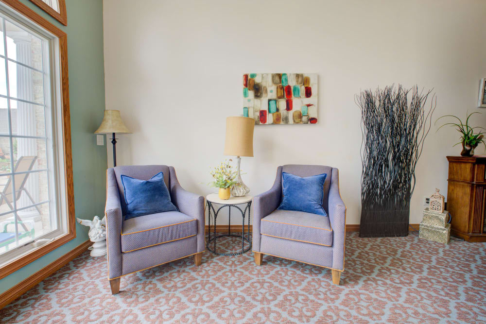 Welcoming chairs with blue cushions and artwork at Brookstone Estates of Vandalia in Vandalia, Illinois