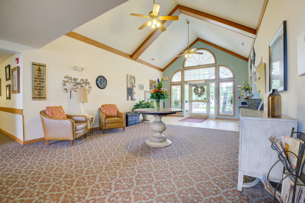 Bright hallway with seating and flowers at Brookstone Estates of Vandalia in Vandalia, Illinois