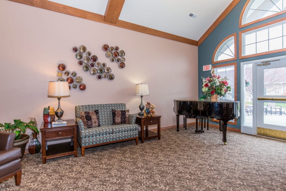 Cozy sitting room complete with piano at Brookstone Estates of Tuscola in Tuscola, Illinois