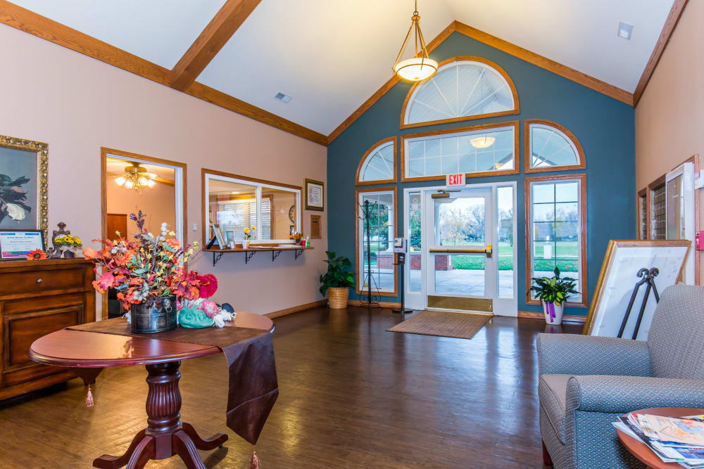 Front entry wall complete with seating, hardwood floors, and flowers at Brookstone Estates of Rantoul in Rantoul, Illinois