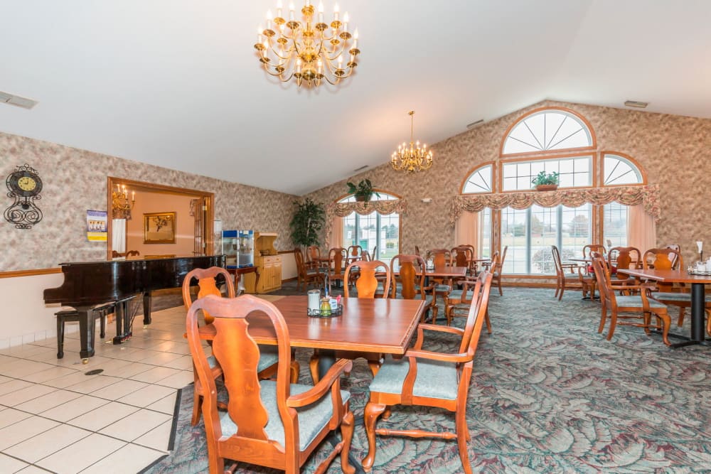 Elegant wood dining room complete with chandeliers and piano at Brookstone Estates of Paris in Paris, Illinois
