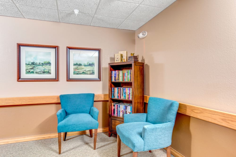 Library room with sky blue chairs and bookshelf at Brookstone Estates of Olney in Olney, Illinois