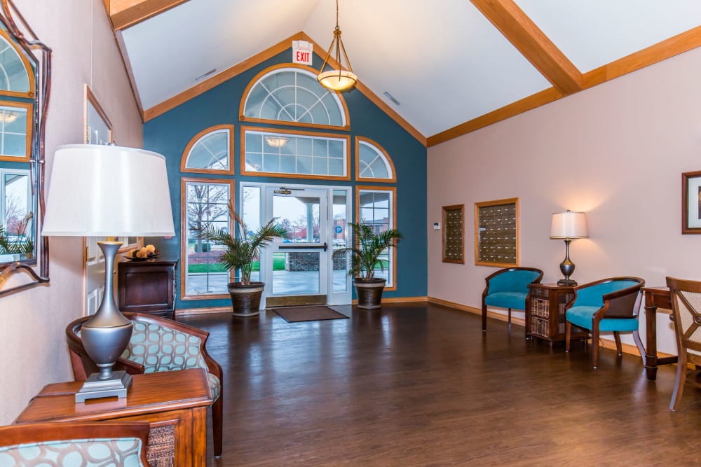 Sitting area with large window, foliage, and hardwood floor at Brookstone Estates of Olney in Olney, Illinois