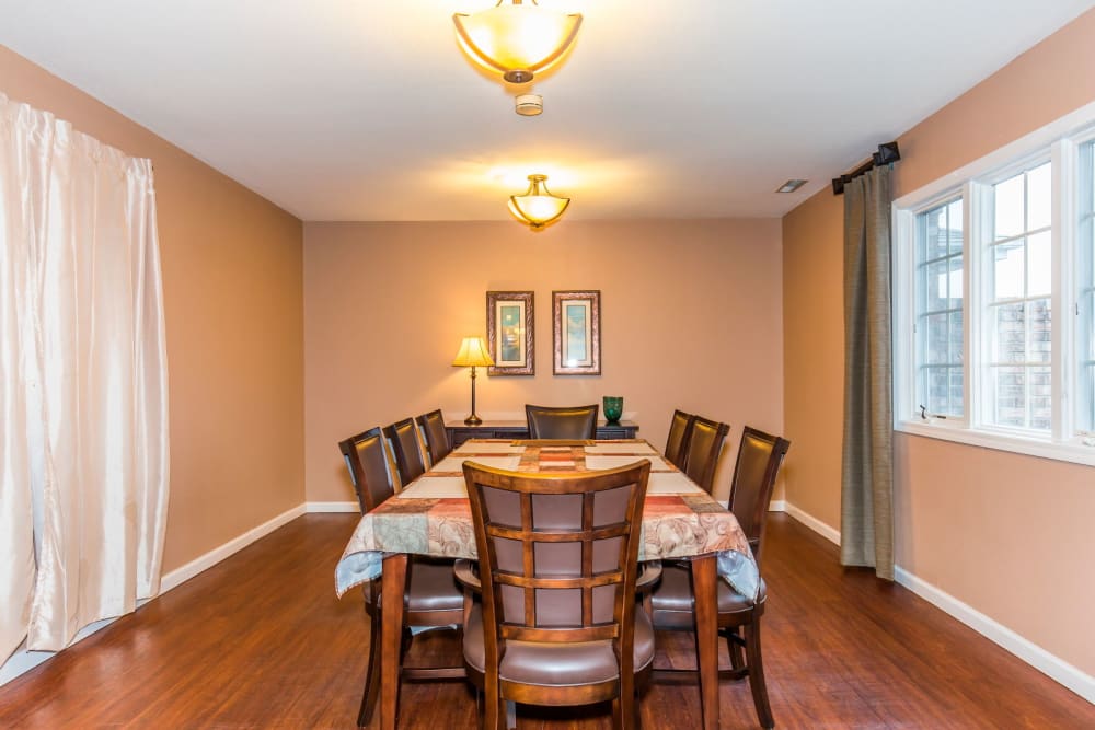 Well lit dining room with hardwood floor at Brookstone Estates of Olney in Olney, Illinois
