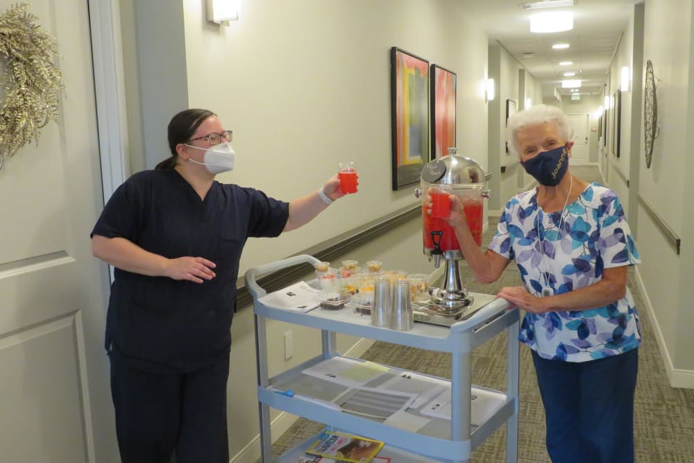 Caretaker serving fruit punch off of a rolling cart at Aspired Living of La Grange in La Grange, Illinois
