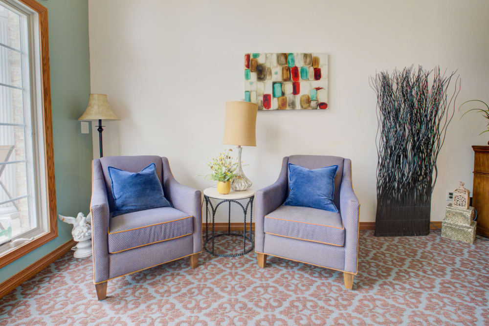 Double armchair seating with lamps and art at Brookstone Estates of Vandalia in Vandalia, Illinois