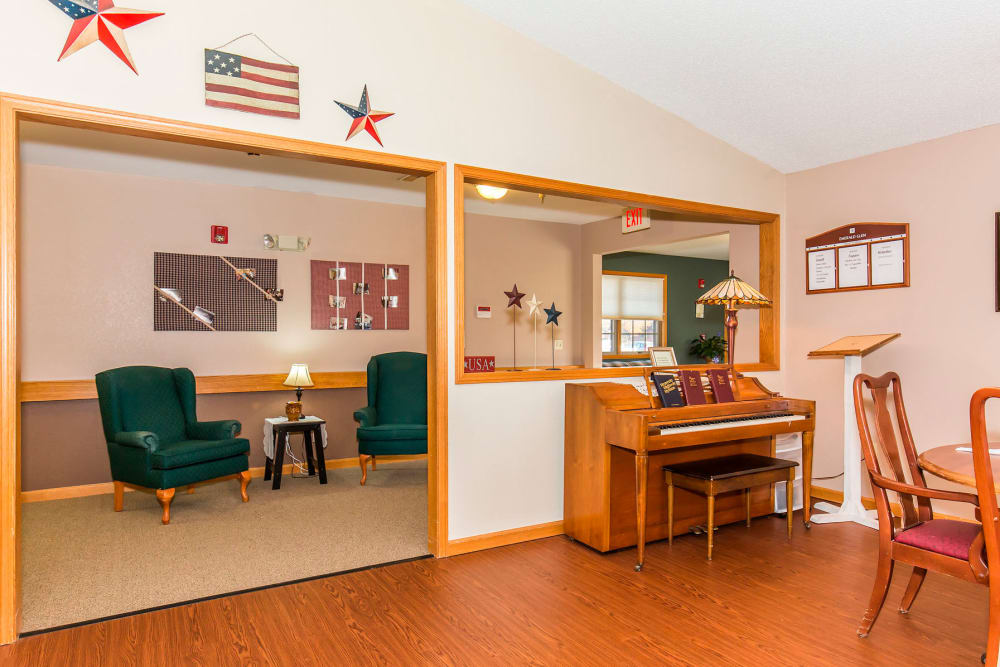 Cozy lounge area complete with armchairs and piano at Emerald Glen of Olney in Olney, Illinois