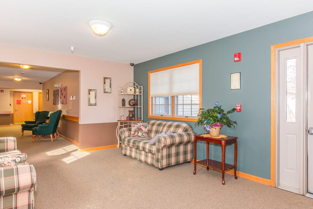 Comfortable sitting room with couch and foliage at Emerald Glen of Olney in Olney, Illinois