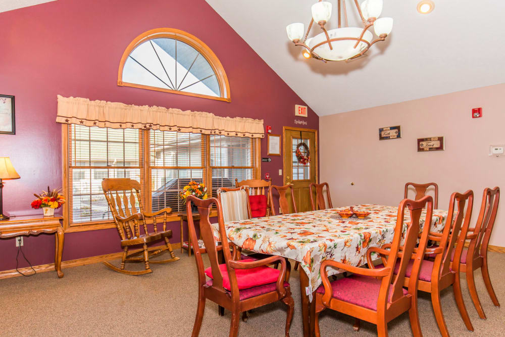 Elegant dining area with red wall, window, and chandelier at Emerald Glen of Olney in Olney, Illinois