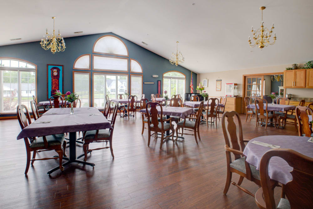 Sunny dinning room with wood accents and chandeliers at Brookstone Estates of Vandalia in Vandalia, Illinois