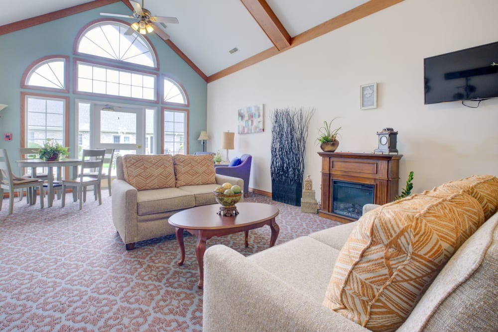 Welcoming airy and sunny sitting room with comfy couches and fireplace at Brookstone Estates of Vandalia in Vandalia, Illinois