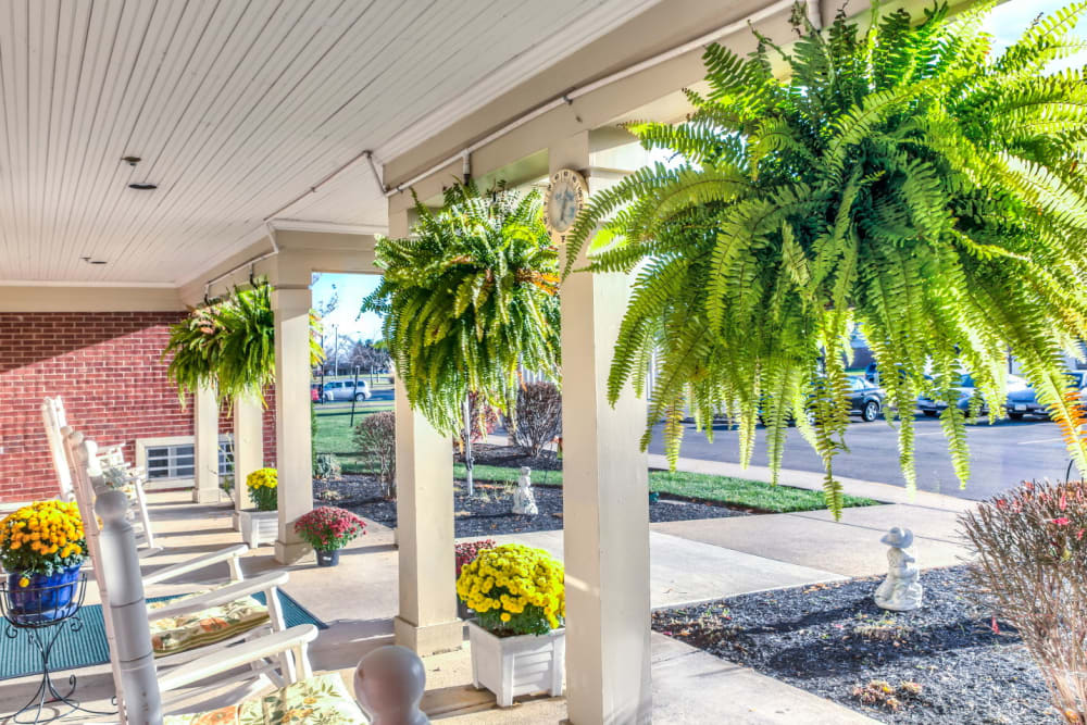 Sunny porch area complete with white chairs and foliage at Carriage Court of Washington Court House in Washington Court House, Ohio