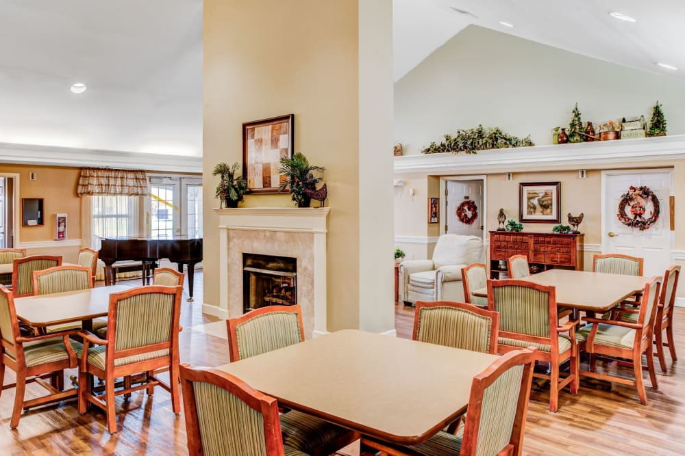 Brightly lit dining room complete with fireplace and piano at Carriage Court of Washington Court House in Washington Court House, Ohio