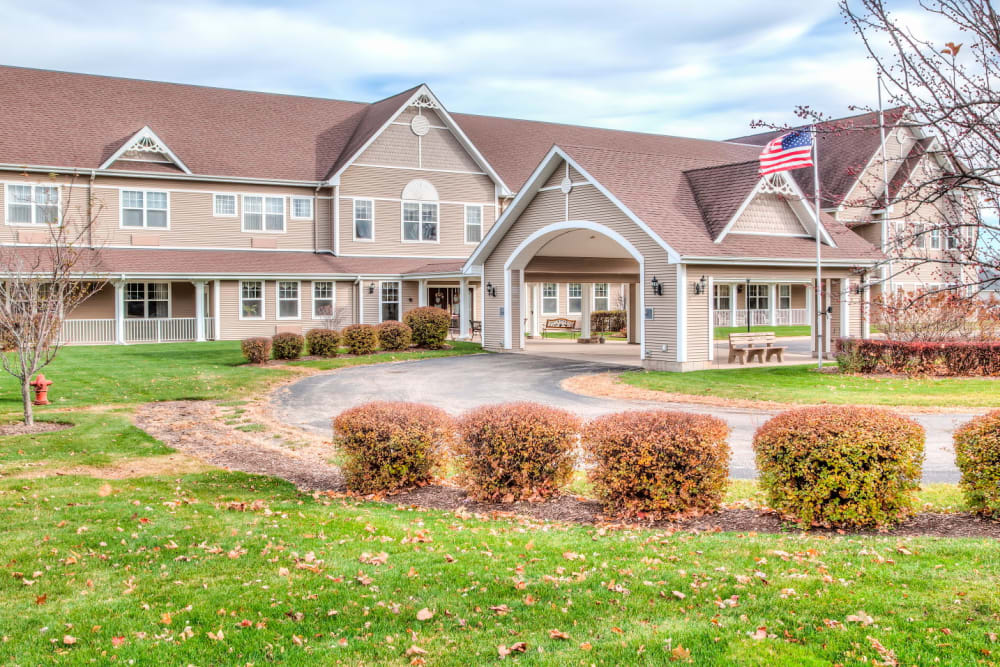 Front entrance to upscale senior living facility with grassy expanse at Grand Victorian of Sycamore in Sycamore, Illinois