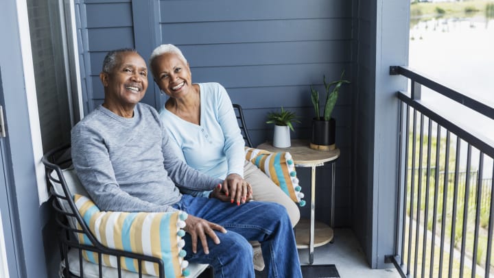 Man and woman moving into senior living and sitting on balcony