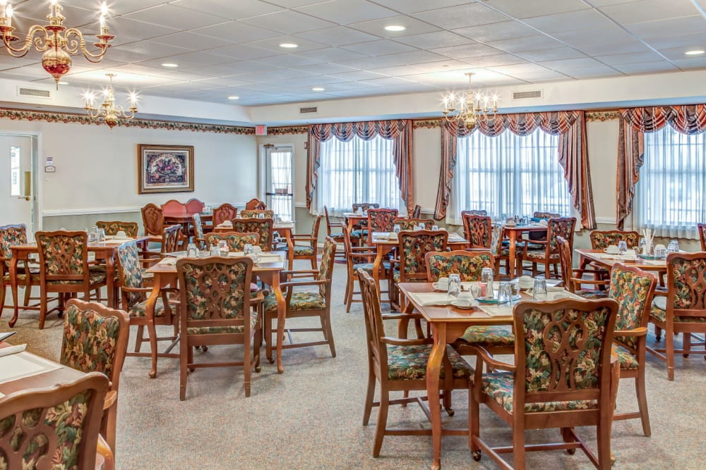 Elegant dining area with wood accents and chandeliers at Grand Victorian of Rockford in Rockford, Illinois