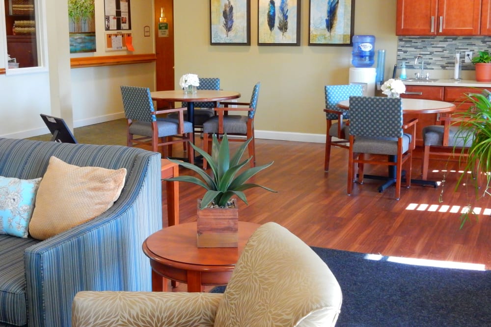 Charming sitting area with tables at upscale senior living facility with armchairs and wood accentsat Carriage Court of Grove City in Grove City, Ohio