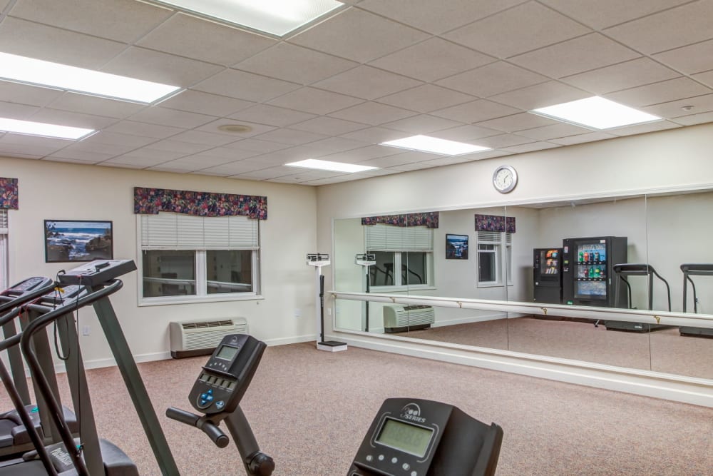 Deluxe exercise studio with machines and mirror at Grand Victorian of Sycamore in Sycamore, Illinois