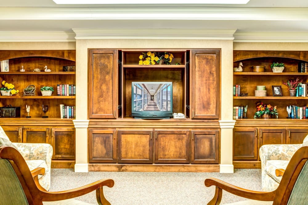 Television room with wood accents and bookshelf at Carriage Court of Washington Court House in Washington Court House, Ohio