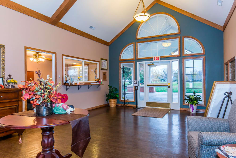 Front entryway with hardwood floors, seating, and flowers at Brookstone Estates of Rantoul in Rantoul, Illinois