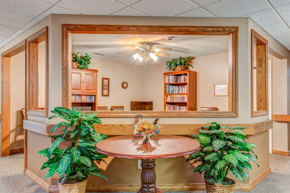 Lounge with bright lighting, foliage, and wood accents  at Brookstone Estates of Rantoul in Rantoul, Illinois