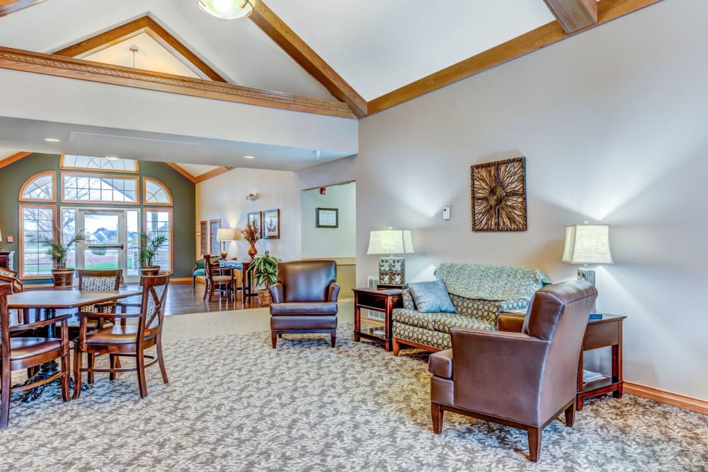 Lounge area with armchair seating and bright lighting at Brookstone Estates of Olney in Olney, Illinois