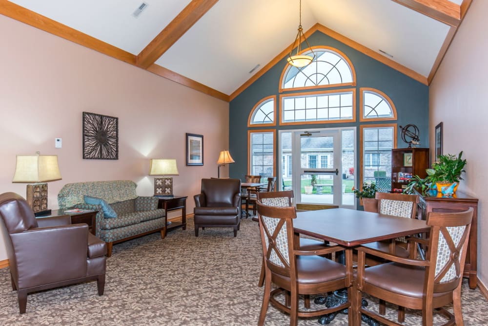 Sitting room with large window and wood table at Brookstone Estates of Olney in Olney, Illinois