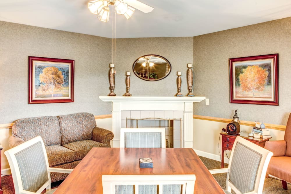 Community sitting room with wood accents,  fireplace, and ample seating at Carriage Court of Washington Court House in Washington Court House, Ohio