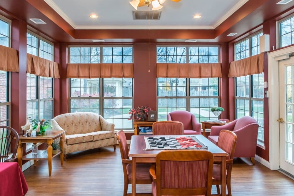 Charming game room with tract lighting, wood accents, armchairs and chess set at Carriage Court of Lancaster in Lancaster, Ohio